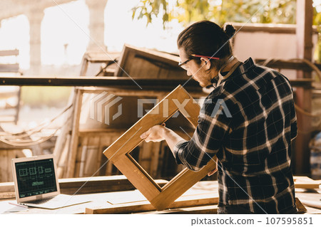 Carpenter Joiner man making wooden furniture in wood workshop professional high skill real authentic handcrafted working people. Carpenter Joiner man making wooden furniture in wood workshop professional high skill real authentic handcrafted working people. 107595851