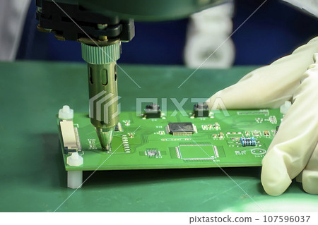 Close up scene the soldering operation by skill operator with rubber finger cot. Close up scene the soldering operation by skill operator with rubber finger cot. 107596037