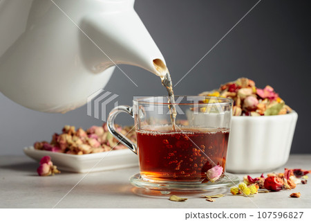 Herbal tea is poured into a mug. Herbal tea is poured into a mug. 107596827