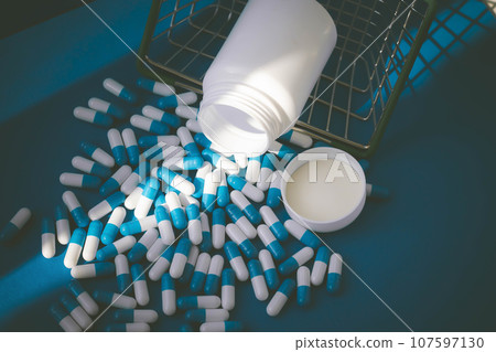 Pills in a grocery basket. Medicine capsules on the table. Buyer at the pharmacy 107597130