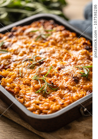 Baked pasta with smoked meat, sausage, egg, cheese and spices. Traditional Czech food 107598286
