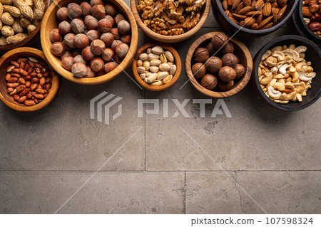 Assortment of nuts in bowls 107598324