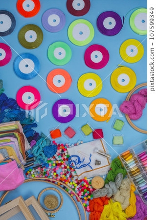 Flat lay DIY with hand embroidery with satin ribbons. Embroidery process with satin ribbons. Flat lay DIY with hand embroidery with satin ribbons. Embroidery process with satin ribbons. 107599349
