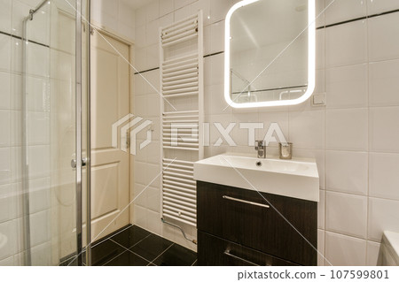 a bathroom with a sink, mirror and shower stall in the corner next to the bathtub on the wall 107599801