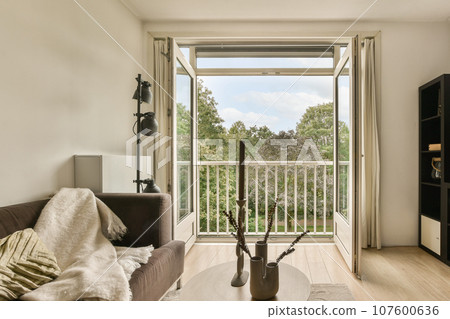 a living room with a couch, coffee table and sliding glass door that leads out to the outside patio area a living room with a couch, coffee table and sliding glass door that leads out to the outside patio area 107600636