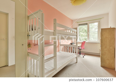 a small room with bunks and a desk in the corner next to an open door that leads to another room a small room with bunks and a desk in the corner next to an open door that leads to another room 107600637