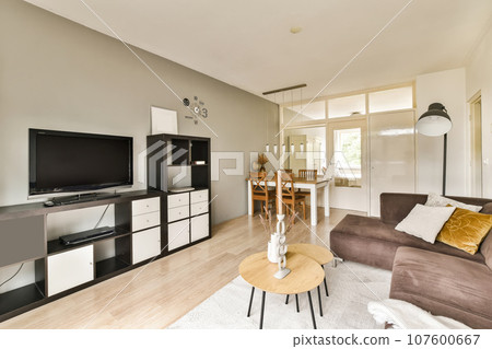 a living room with a couch, coffee table, and television on the wall in it's centerpiece a living room with a couch, coffee table, and television on the wall in it's centerpiece 107600667