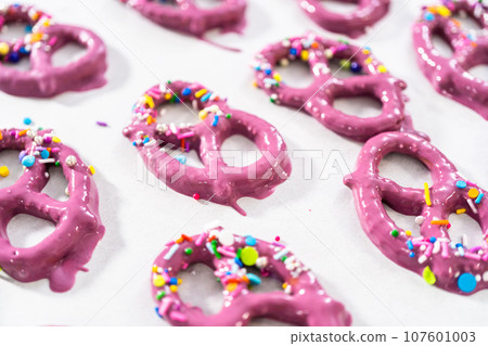 Dipping pretzels twists into melted chocolate to make mermaid pretzel twists. 107601003