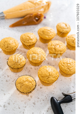 Cooling freshly baked dulce de leche cupcakes on a kitchen counter. Cooling freshly baked dulce de leche cupcakes on a kitchen counter. 107601029