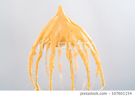 Freshly whipped dulce de leche buttercream frosting on a whisk. 107601154