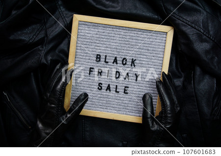 Hands in black gloves hold a frame with the inscription - Black Friday sale Hands in black gloves hold a frame with the inscription - Black Friday sale 107601683