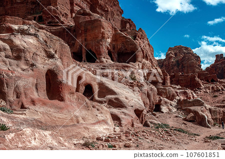View of the Temples and caves carved into the sandstone rock in the gorge. Petra, Jordan 107601851