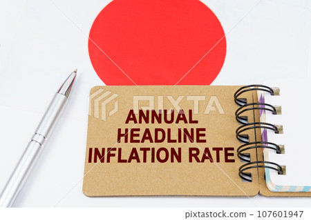 Economy and finance concept. On the flag of Japan lies a pen and a notebook with the inscription - Annual headline inflation rate Economy and finance concept. On the flag of Japan lies a pen and a notebook with the inscription - Annual headline inflation rate 107601947