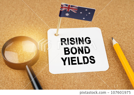 Economy and finance concept. On the table are a magnifying glass, a pencil, the flag of Australia and a sheet of paper with the inscription - rising bond yields. Economy and finance concept. On the table are a magnifying glass, a pencil, the flag of Australia and a sheet of paper with the inscription - rising bond yields. 107601975
