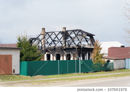 The burnt premises of the house and the roof with the attic after the fire. Side view. The burnt premises of the house and the roof with the attic after the fire. Side view. 107601978