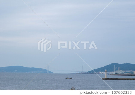 平靜海浪的假期。從神戶港島眺望明石海峽大橋。 平靜海浪的假期。從神戶港島眺望明石海峽大橋。 107602333