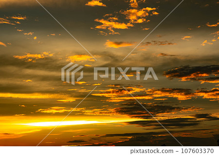 The golden clouds and the golden sun in the evening are very beautiful nature 107603370