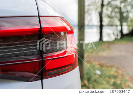 Modern white car xenon lamp headlight, back view close up. Modern car closeup of headlight Modern white car xenon lamp headlight, back view close up. Modern car closeup of headlight 107603447