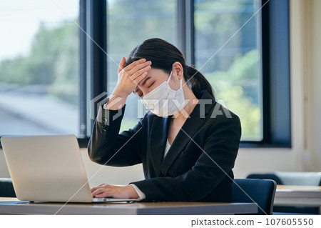 A young woman who has a headache and puts her hand on her forehead 107605550