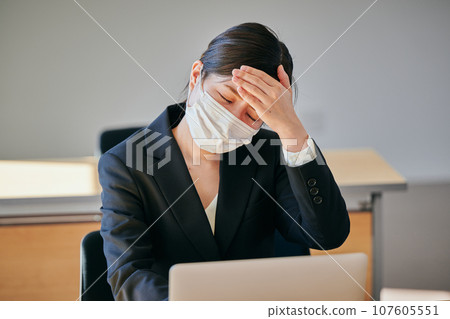 A young woman who has a headache and puts her hand on her forehead 107605551