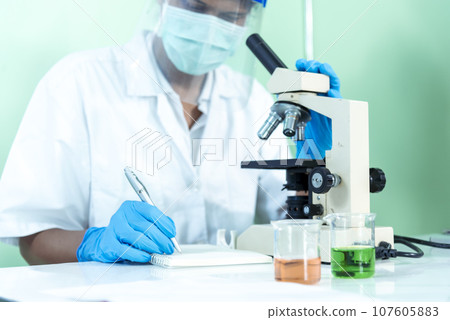 Scientist man look into Microscope research in science laboratory. Asian scientist looking equipment laboratory chemistry labs. Covid-19 coronavirus biochemistry research experiment vaccine concept 107605883