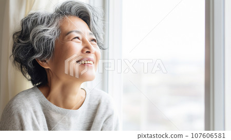 一位日本老婦人在明亮的窗戶前微笑的肖像 107606581