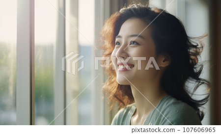 一位 20 至 30 多歲的日本女性在明亮的窗戶前微笑的肖像 107606965
