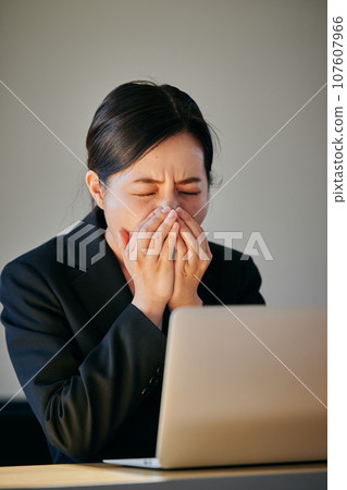 A young woman who can't stop sneezing or having a runny nose due to hay fever A young woman who can't stop sneezing or having a runny nose due to hay fever 107607966