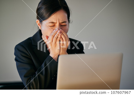 A young woman who can't stop sneezing or having a runny nose due to hay fever A young woman who can't stop sneezing or having a runny nose due to hay fever 107607967