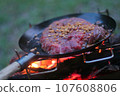 Large steak on bonfire and frying pan 107608806