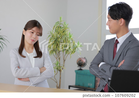 1on1_Business woman thinking with her arms folded when asked about a problem by a manager 1 107609202