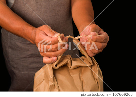 Tie and untie knots in rice bags 107609203