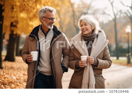 A middle-aged Caucasian couple walking through an autumn park. 107610446