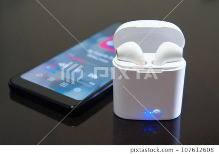 Listen to music with wireless earphones and smartphone Listen to music with wireless earphones and smartphone 107612608