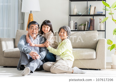 Granddaughter and senior couple relaxing in the living room Granddaughter and senior couple relaxing in the living room 107617206