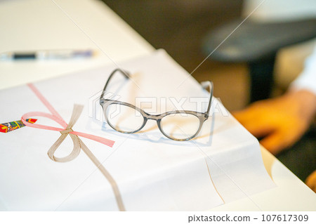 Attach red paper to gift items and prepare glasses. 107617309