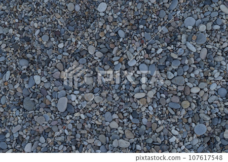 Smooth round pebbles on a Mediterranean beach background Smooth round pebbles on a Mediterranean beach background 107617548