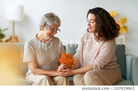 woman and her senior mother with autumn leaves woman and her senior mother with autumn leaves 107619661