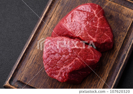 Fresh juicy raw beef medallions with salt and spices 107620320