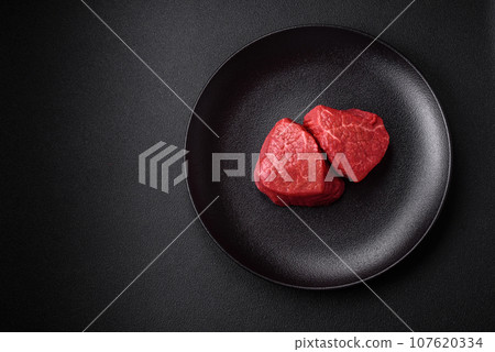 Fresh juicy raw beef medallions with salt and spices 107620334