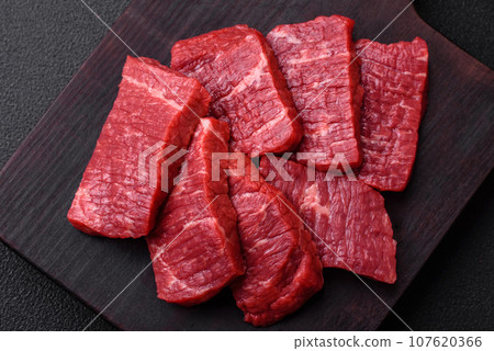 Fresh juicy raw beef slices with salt and spices 107620366