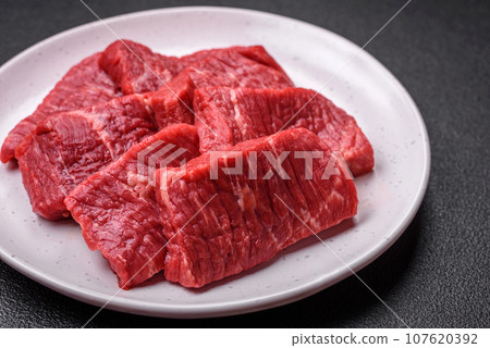 Fresh juicy raw beef slices with salt and spices 107620392