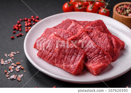 Fresh juicy raw beef slices with salt and spices Fresh juicy raw beef slices with salt and spices 107620395