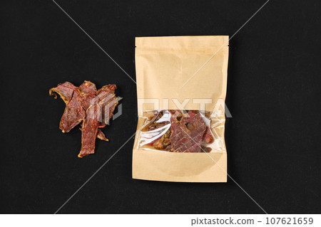 Overhead view of dehydrated lamb jerky meat in paper package 107621659