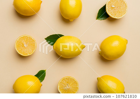 Many fresh ripe lemons as colored background, top view. Elegant background of lemon and lemon slices Top view flat lay 107621810