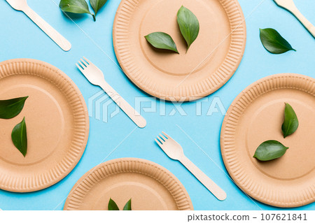 set of empty reusable disposable eco-friendly plates, cups, utensils on light white colored table background. top view. Biodegradable craft dishes. Recycling concept. Close-up set of empty reusable disposable eco-friendly plates, cups, utensils on light white colored table background. top view. Biodegradable craft dishes. Recycling concept. Close-up 107621841