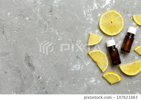 Bottles with lemon fruit essential oil on wooden background. alternative medicine top view with copy space 107621863