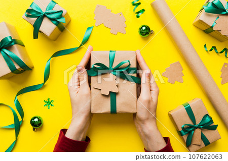 Woman hands holding gift box, preparing surprise for holiday, top view, Christmas and New Year concept 107622063