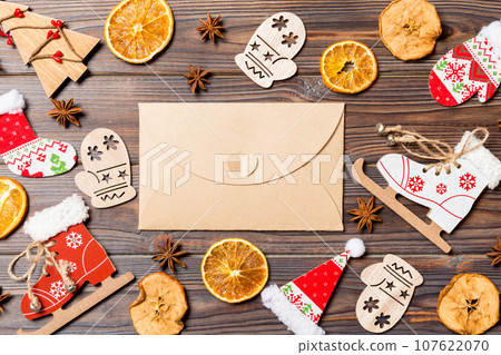 Top view of envelope on festive wooden background. Christmas toys and decorations. New Year time concept 107622070