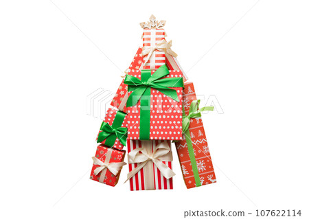Isolated Christmas tree made of beautifuly wrapped presents on colored background, view from above. New Year gift box minimal concept Isolated Christmas tree made of beautifuly wrapped presents on colored background, view from above. New Year gift box minimal concept 107622114